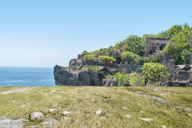 El paisaje de hierba verde y rocas en el acantilado con paisaje marino