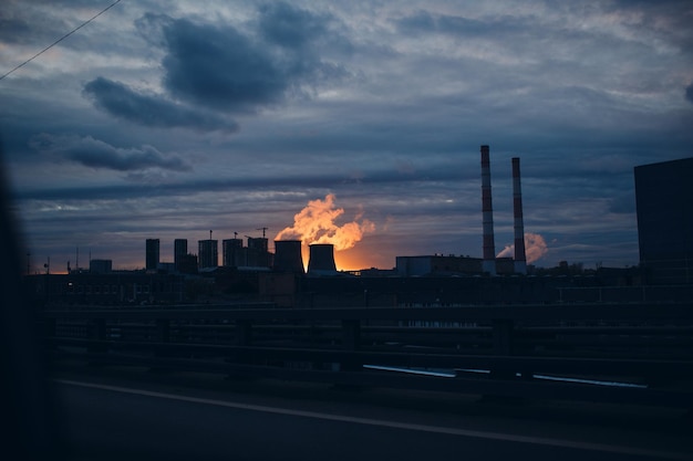 Paisaje industrial y humo de las chimeneas al fondo del atardecer