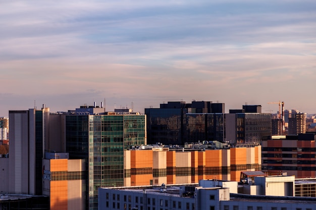 Paisaje industrial urbano en la noche al atardecer. Hermoso cielo azul, edificios comerciales creativos y edificios residenciales.