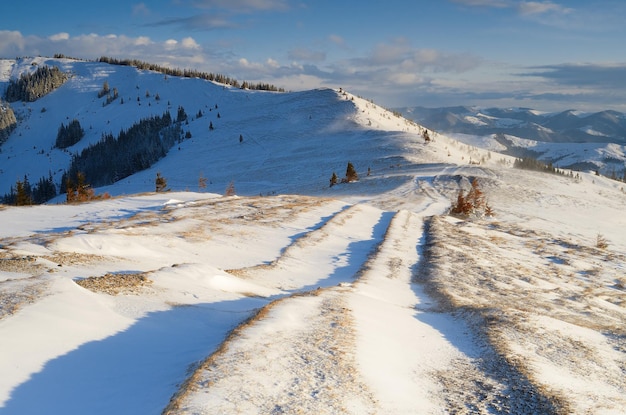 Paisaje invernal con una carretera en las montañas. Viento fuerte