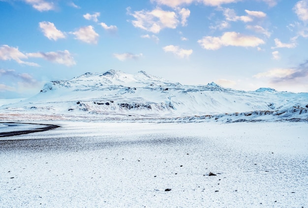 Paisaje invernal de Islandia Recorriendo el Anillo de Oro en Islandia en coche Invierno cuando el suelo y las montañas están cubiertos de nieve Playa de arena negra