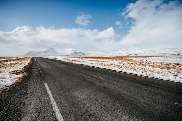 Paisaje invernal de Islandia Viajando a lo largo del Anillo de Oro en Islandia en coche Invierno cuando el suelo y las montañas están cubiertos de nieve Carretera invernal