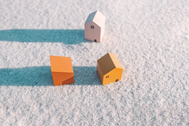 Paisaje invernal con modelo en miniatura de casas de madera sobre fondo de nieve invernal. Casa, préstamo, concepto de inversión de dinero.