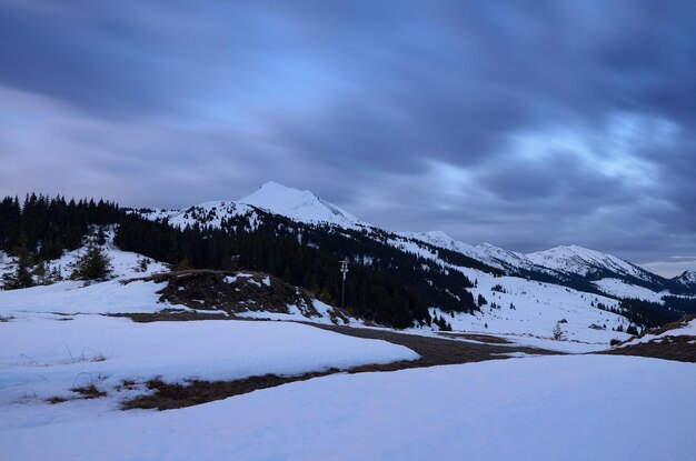 Paisaje invernal con montañas en el crepúsculo vespertino