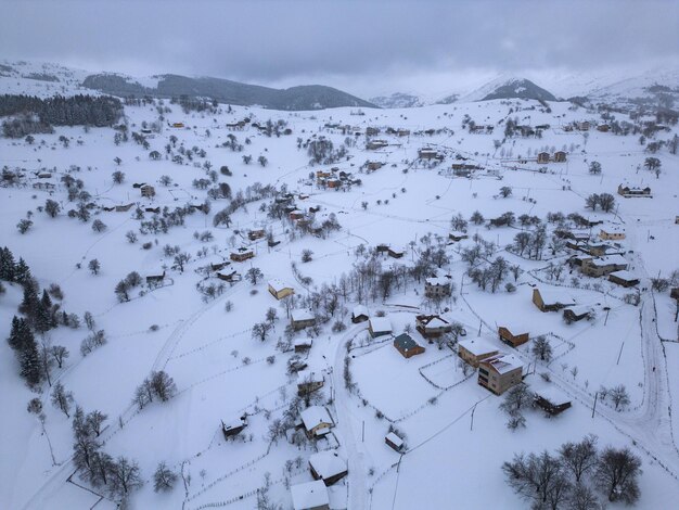 Paisaje invernal con pequeñas casas de pueblo entre bosques cubiertos de nieve en las montañas frías Giresun Turquía