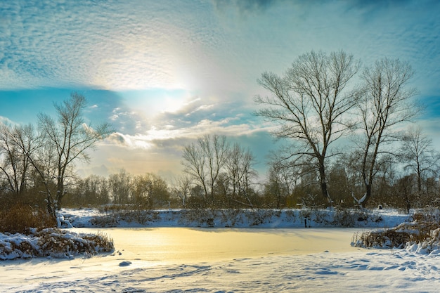 Paisaje invernal con río congelado en un día soleado y frío