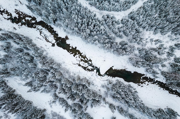 Paisaje invernal con vista de drone de arriba hacia abajo del río congelado