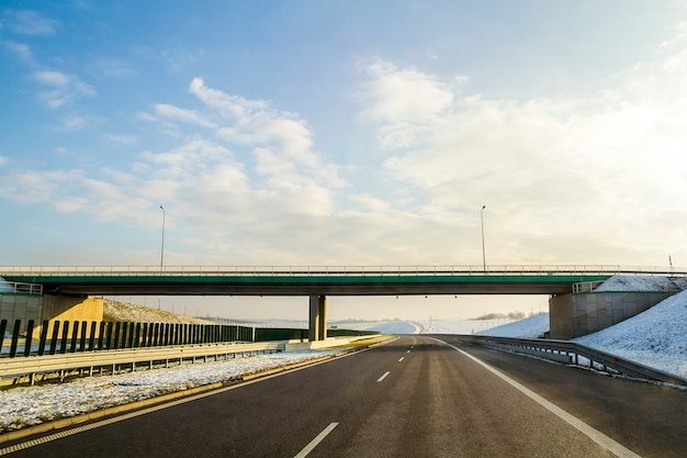 Paisaje de invierno con carretera asfaltada al horizonte.