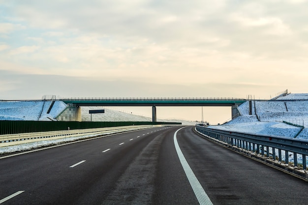 Foto paisaje de invierno con carretera asfaltada al horizonte.