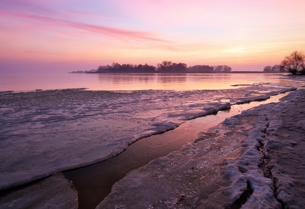 Paisaje de invierno con lago y cielo al atardecer. Composición de la naturaleza.