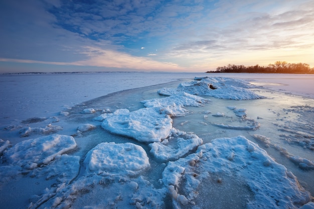 Paisaje de invierno con lago congelado y cielo al atardecer. Composición de la naturaleza.