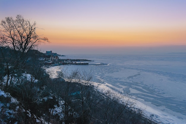 Paisaje de invierno Puesta de sol sobre el mar helado