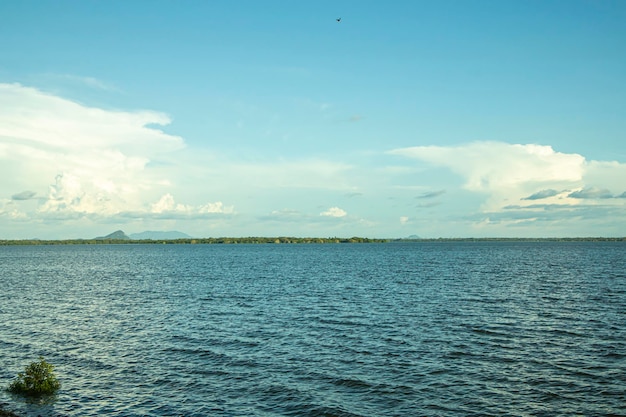 Paisaje del lago con cielo azul y nubes blancas.