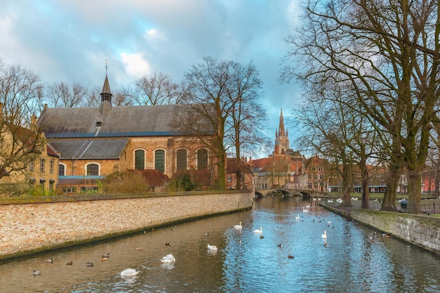 Paisaje en el lago Minnewater, iglesia y puente en Brujas, Bélgica