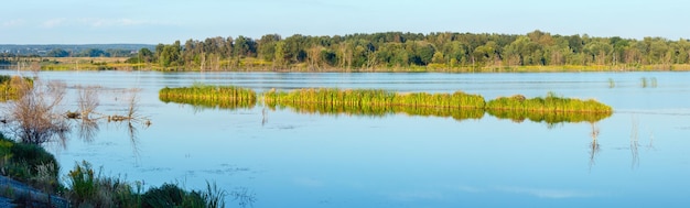 Paisaje del lago de verano por la noche con reflejos de plantas en la superficie del agua cerca del asentamiento de Shklo Lviv Oblast Ucrania Panorama