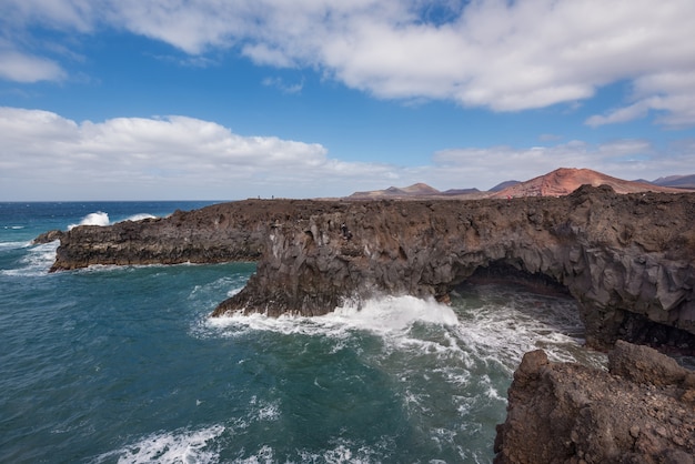 Paisaje de Lanzarote. Costa de Los Hervideros, cuevas de lava, acantilados y océano ondulado.