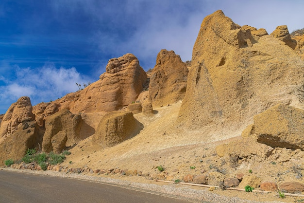 Foto paisaje lunar en teno alto con luz solar y cielo azul con nubes de fondo en tenerife