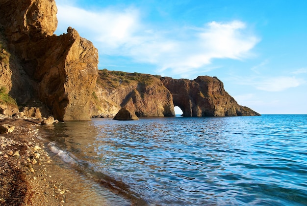 Paisaje de mar con gruta en la roca.