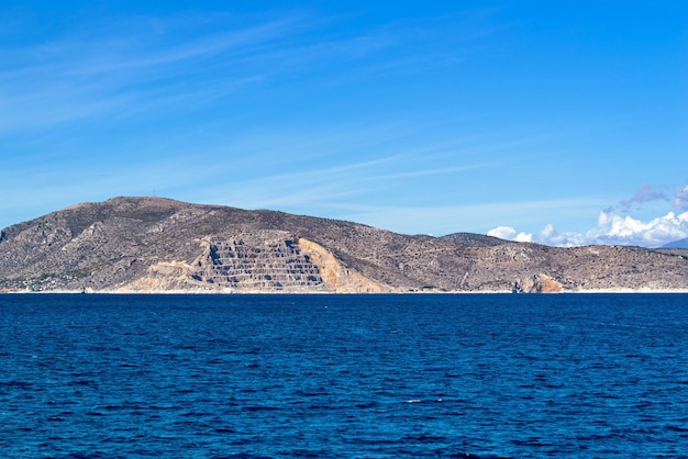 Paisaje de mar con montañas y colinas en el horizonte y el cielo azul claro