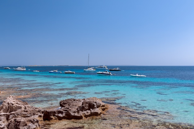 Paisaje marino del hermoso mar turquesa y yates en Ibiza, España