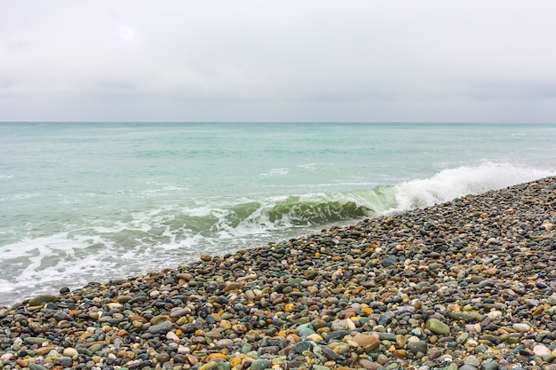 Paisaje marino en mal tiempo nublado con guijarros en la playa