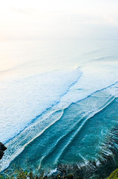 Paisaje marino, océano al atardecer. Costa del océano con olas cerca del templo de Uluwatu al atardecer, Bali, Indonesia.