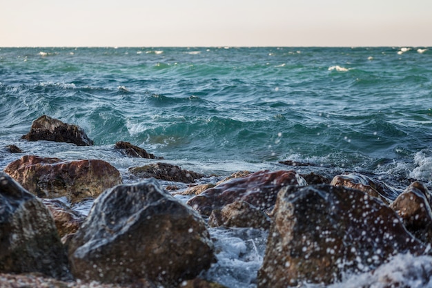 Paisaje marino con rocas, espuma y rocío de las olas.