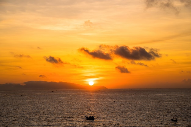 Paisaje marino tropical con un bote en la playa de arena al amanecer o atardecer nublado Hermosa playa tropical al atardecer con bote pequeño y cielo rosa para viajes y vacaciones en tiempo de relajación de vacaciones Ciudad de Vung tau