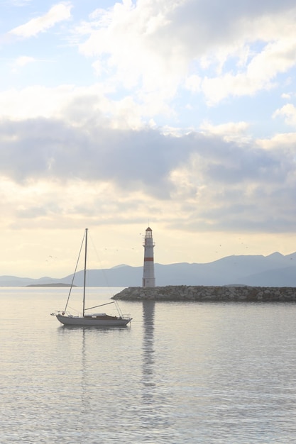 Paisaje marítimo al sol Faro y navegaciones en la costa La ciudad costera de Turgutreis y el sol espectacular