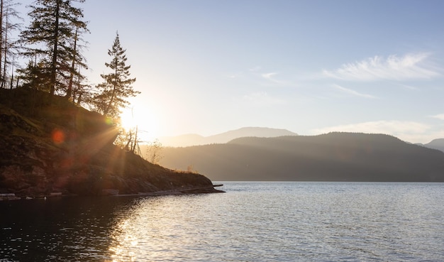 Paisaje de montaña canadiense con árboles y lago soleado cielo de puesta de sol de verano