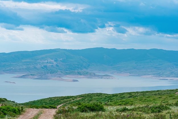 Paisaje de montaña con una carretera y un lago lejano