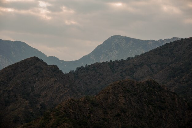 Paisaje de la montaña bajo el cielo nublado con luz