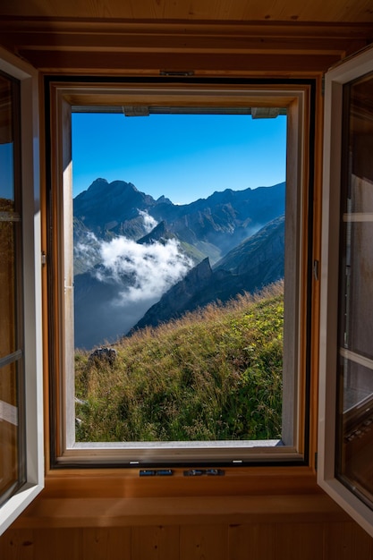 Un paisaje de montaña fotografiado desde una casa la ventana forma el marco de la imagen