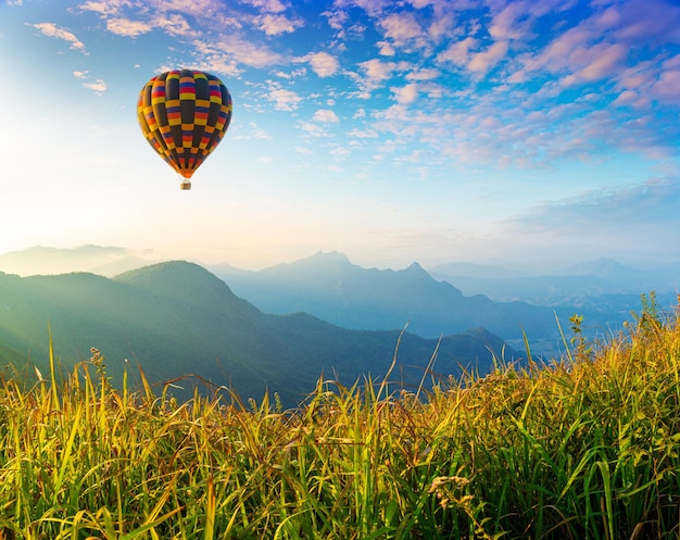 Paisaje de montaña con globos aerostáticos y hermoso cielo.