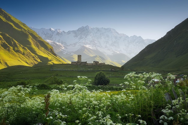 Paisaje de montaña con iglesia en la colina. Mañana en un valle de montaña. Pueblo de Ushguli, Zemo Svaneti, Georgia. Cordillera caucásica principal de la montaña Shkhara