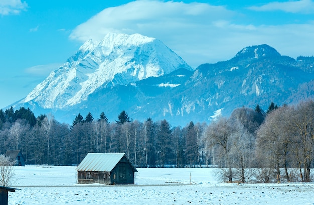 Paisaje de montaña de invierno con cobertizo de madera (Austria).