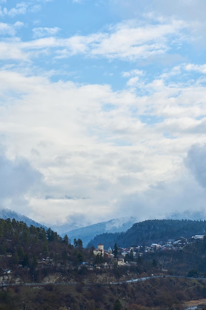 Paisaje de montaña de invierno Pequeño pueblo entre montañas Una nube se cierne sobre la ciudad