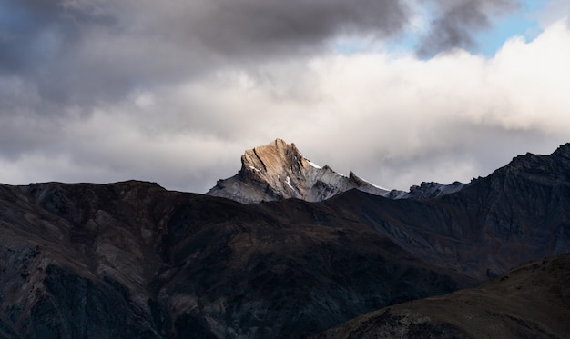 Paisaje de montaña, luz solar en el pico de la montaña con cielo nublado