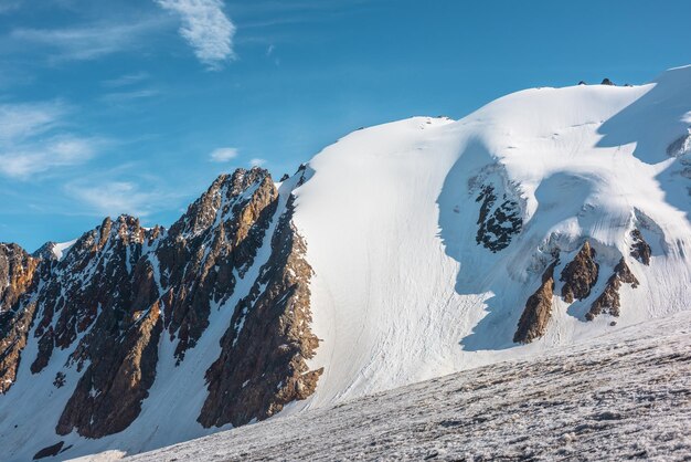 Paisaje de montaña minimalista con un gran glaciar a la luz del sol Minimalismo nevado simple con lengua glacial a la luz del sol Mínima vista alpina a las cimas de las montañas nevadas a gran altura en un día soleado