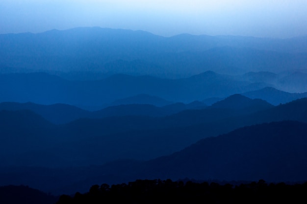 Paisaje de montaña misterioso azul oscuro en el cielo nublado del atardecer