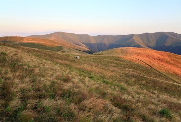 Paisaje de montaña nublado de verano con campamento turístico en pendiente (Ucrania, montañas de los Cárpatos)