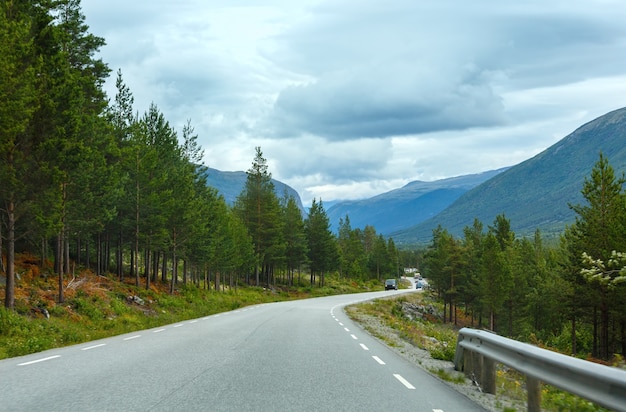 Paisaje de montaña nublado de verano con carretera.