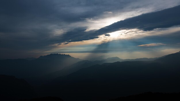 Paisaje de montaña con rayos de sol atravesando las nubes