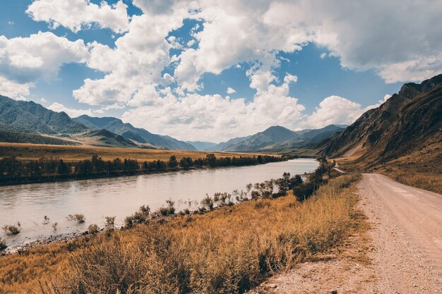 Paisaje de montaña con remaches y camino de tierra.