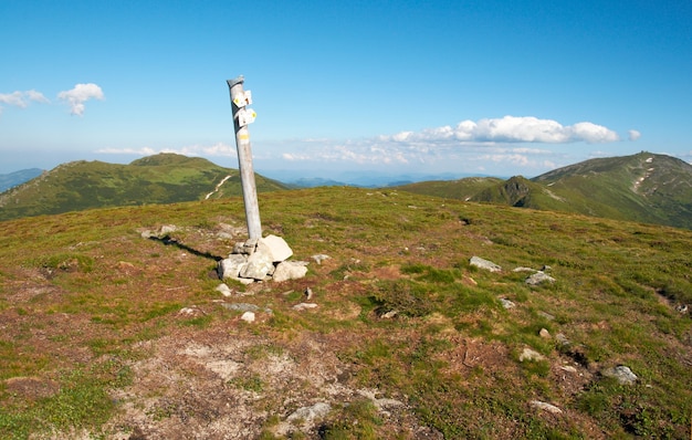 Paisaje de montaña de verano con señal de dirección