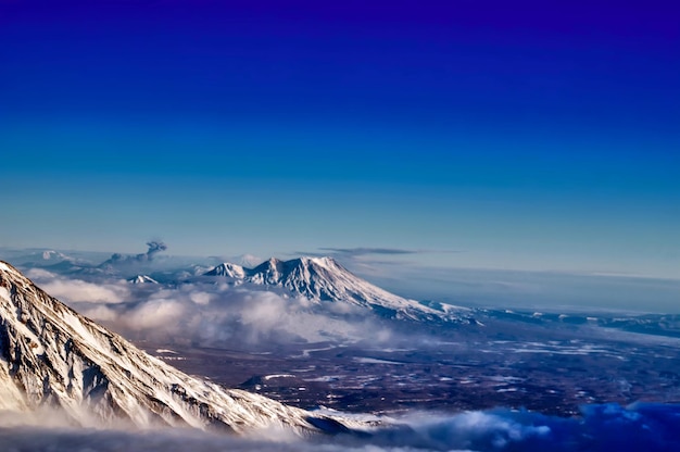 Paisaje de montaña con un volcán en erupción Vista desde la ventana del avión