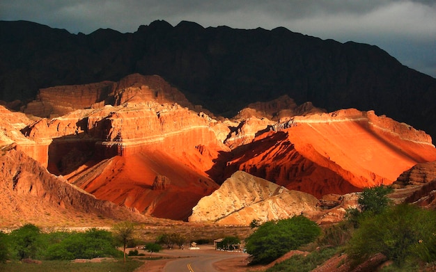 Paisaje con montañas de arenisca roja en el claroscuro de la puesta de sol