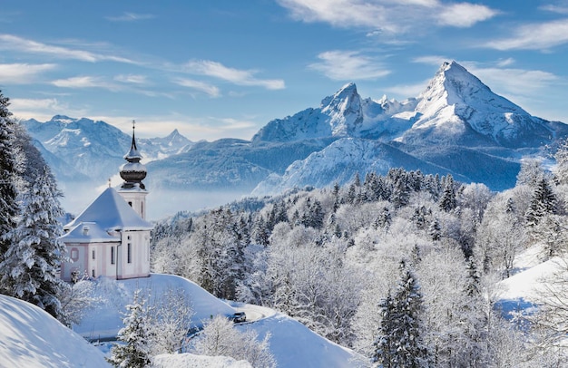 Paisaje de montañas de invierno con la iglesia y el cielo azul