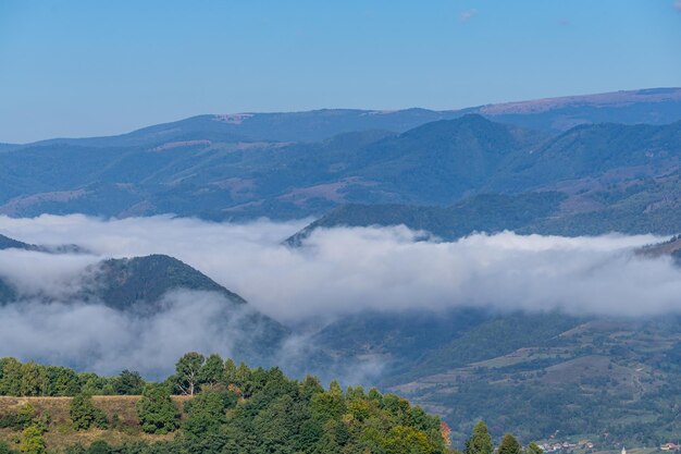 Paisaje con montañas y nubes que cubren el valle, vista panorámica en la naturaleza.