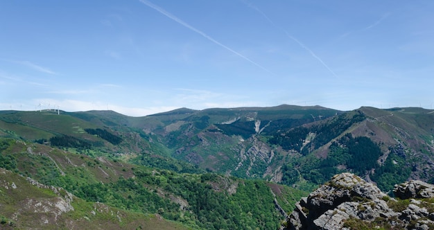 Paisaje de montañas verdes con árboles y rocas